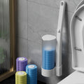 Cleaning brush with cleaning brushes container next to toilet on a gray tiled floor