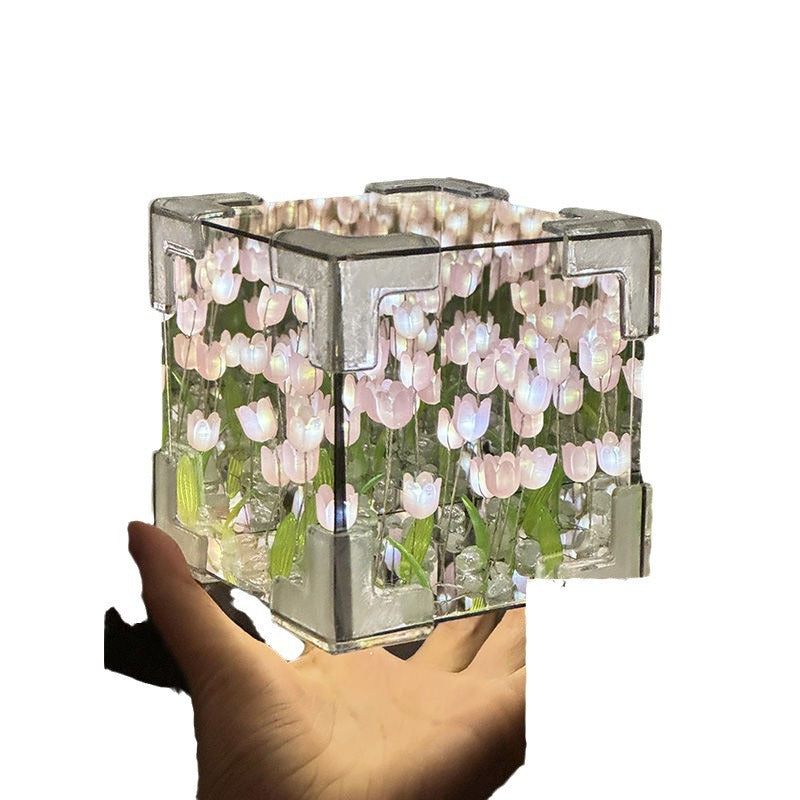 Transparent cube with floral design held by a hand on a white background